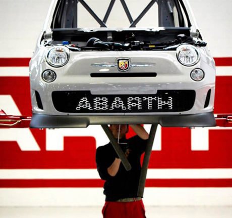 Meccanico della Squadra Corse lavora alla scocca di un'Abarth sul ponte